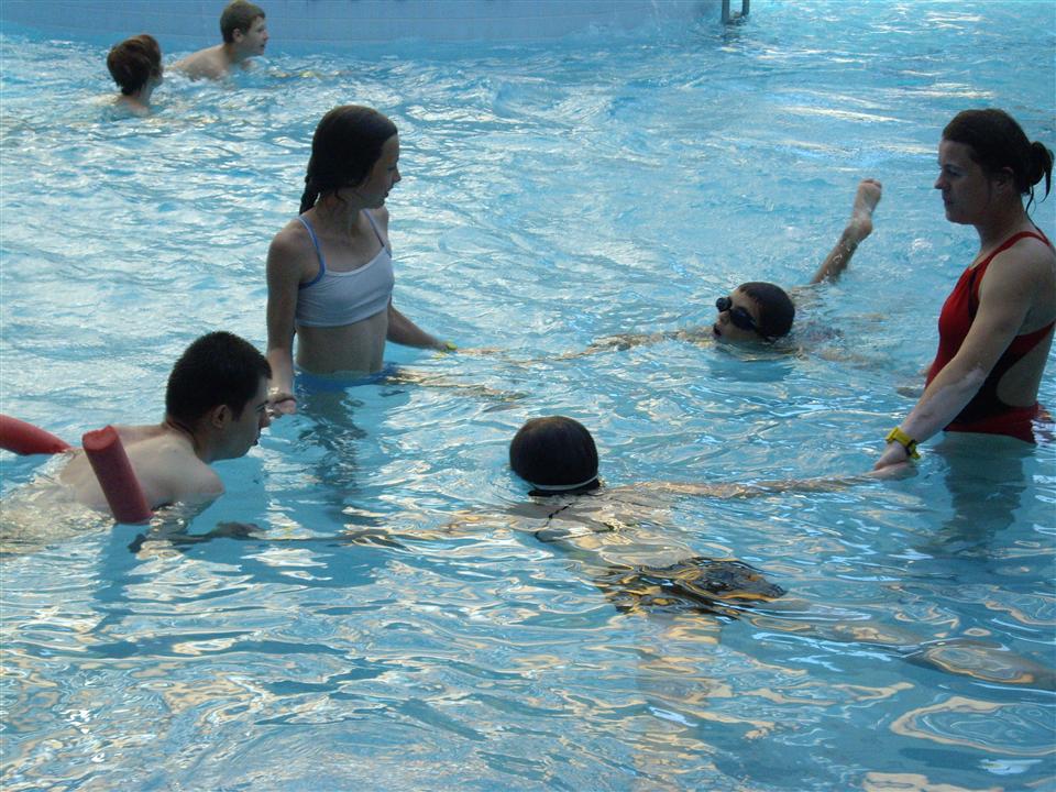 Dzieci wraz z rehabilitantką biorą udział w zajęciach na basenie